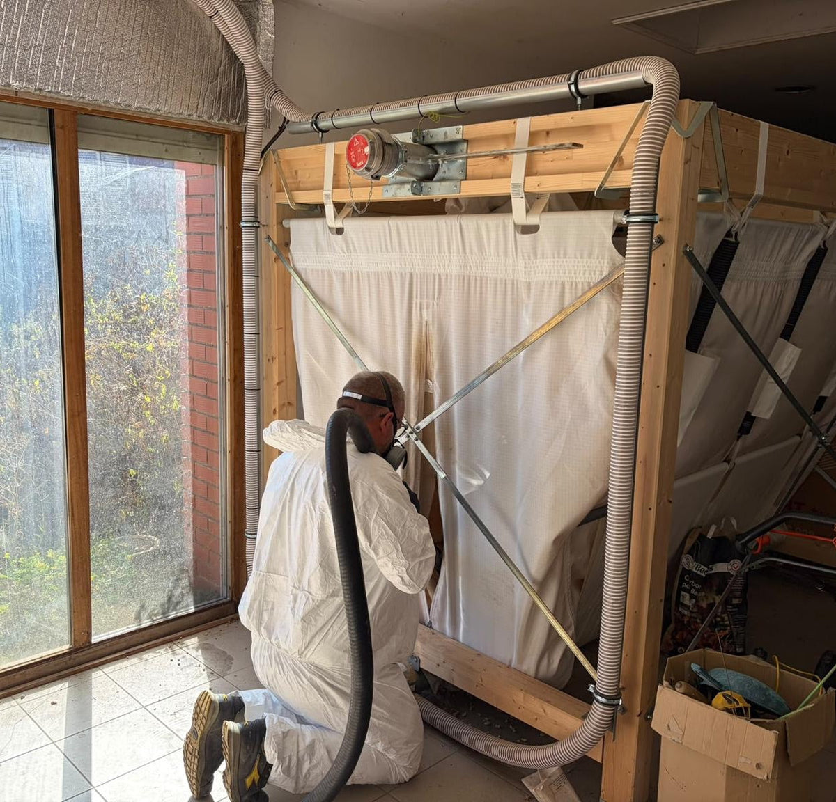 Technicien Delicourt Energies en combinaison de protection nettoyant un silo textile à granulés